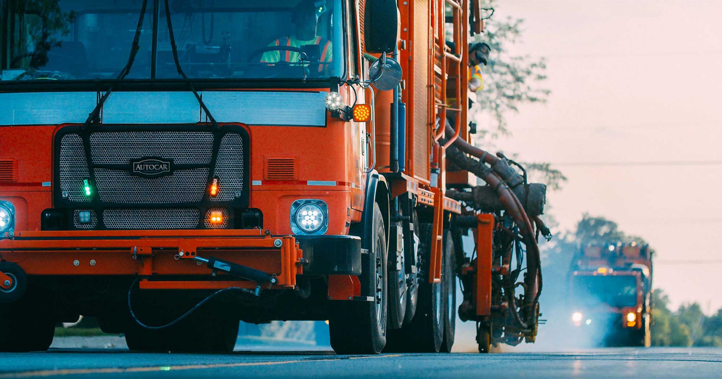 Trucks painting lines onto a roadway